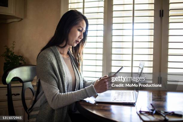 young woman using mobile device at home - spam photos et images de collection