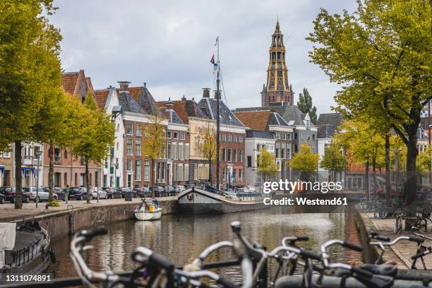 netherlands, groningen, city canal with row of townhouses in background - groningen fotografías e imágenes de stock