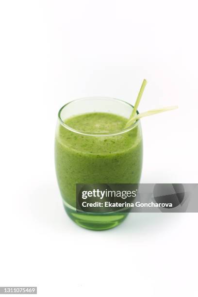 green fruit and vegetable smoothie in a glass cup on a white isolated background. - orange juice glass white background stock pictures, royalty-free photos & images