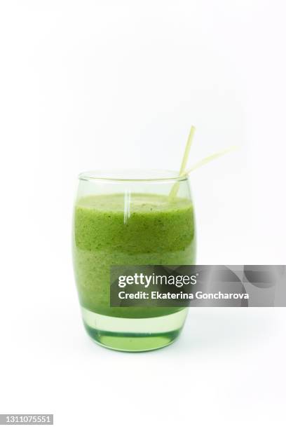 green fruit and vegetable smoothie in a glass cup on a white isolated background. - juice foto e immagini stock