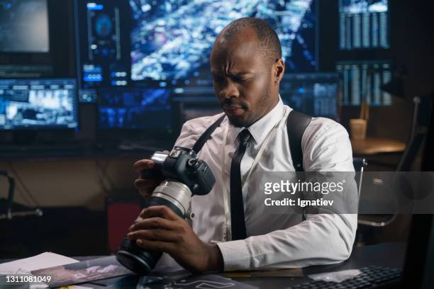 the detective is looking for evidence of the guilt of unknown cybercriminals who staged an anonymous hacker attack. he has photos of criminals at his disposal. - future proof stock pictures, royalty-free photos & images