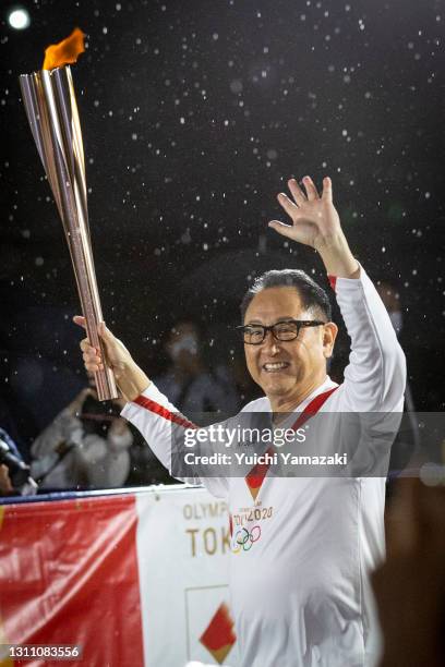 Toyota Motor Co President Akio Toyoda runs with the Olympic torch during the Tokyo Olympic Games Torch Relay on April 06, 2021 in Toyota, Aichi,...