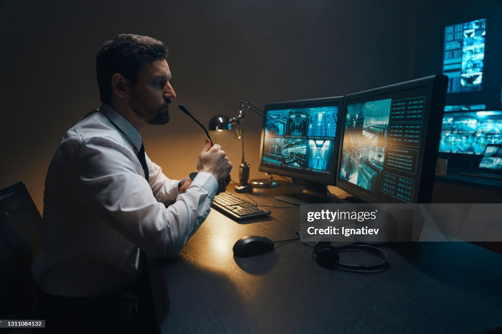 Especialistas em suporte à segurança profissional e segurança do sistema trabalhando em computadores na sala de controle de monitoramento com telas digitais com dados de servidores, rede blockchain e mapas de vigilância.