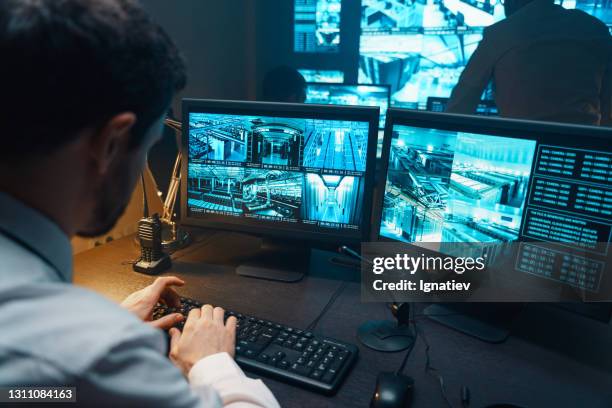 guardia de seguridad observando el sistema de seguridad de monitoreo de vídeo. - vigilancia fotografías e imágenes de stock