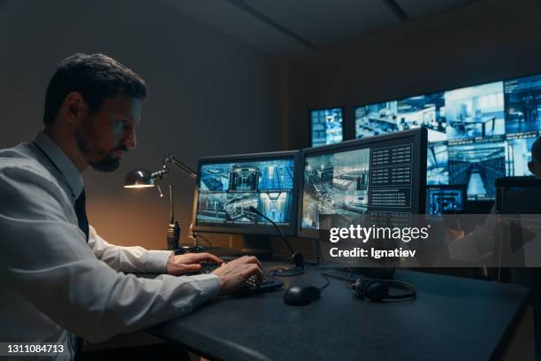 guardias de seguridad monitoreando modernas cámaras cctv en el interior - cámara de seguridad fotografías e imágenes de stock