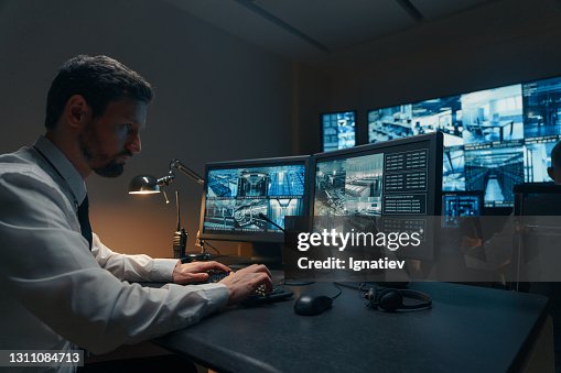 Guardie di sicurezza che monitorano le moderne telecamere a circuito chiuso all'interno Guardie di sicurezza che monitorano le moderne telecamere a circuito chiuso all'interno