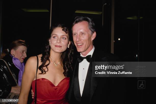 Chris Jasky, wearing a red outfit with s sweetheart neckline, and American actor James Woods, in a dinner jacket, attend the 7th Annual American...