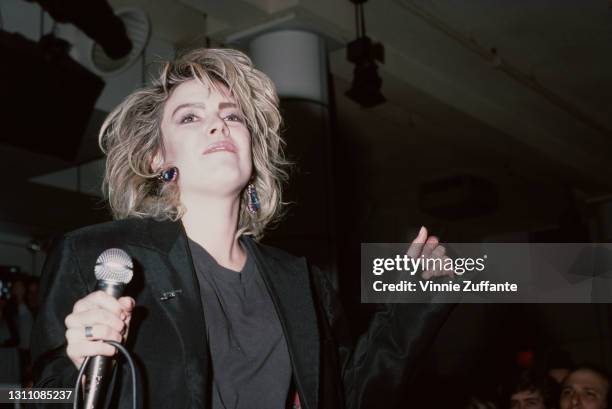 British singer Kim Wilde, dressed in black with a microphone in her right hand, performs in concert at Private Eyes, a nightclub in New York City,...