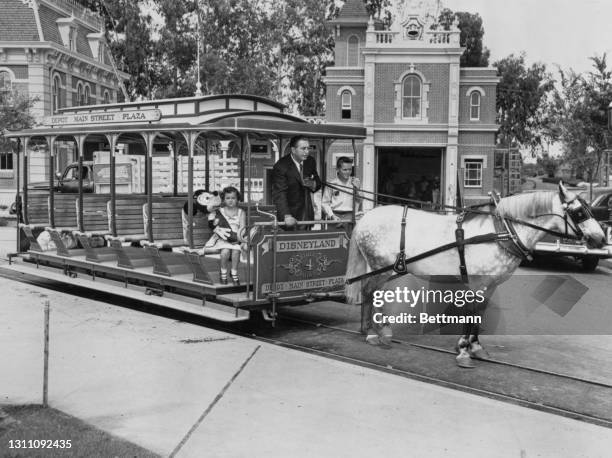 American animator and film producer Walt Disney takes the reins of a horsecar as he gives two young Americans - cousins Sybil Stanton and Billy...