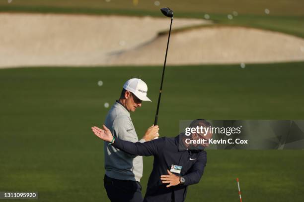 Justin Rose of England works with coach Sean Foley on the range during a practice round prior to the Masters at Augusta National Golf Club on April...