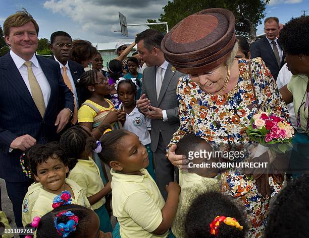 Netherlands' Queen Beatrix hugs a student during her visit to the Prinses Margrietschool in Willemstad, Curacao, on November 1, 2011. The Royal...