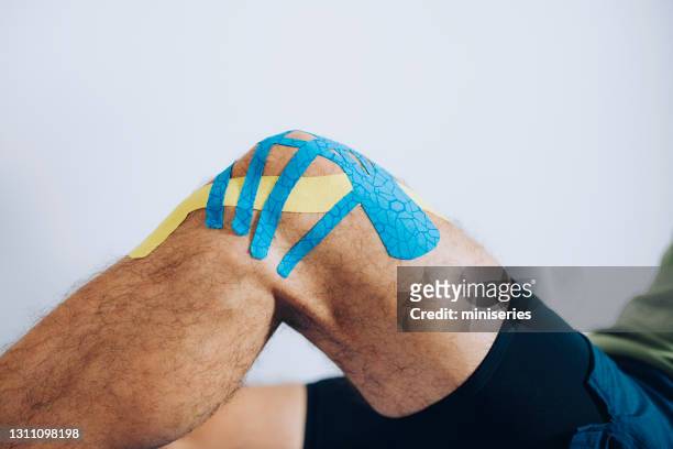human knee with applied kinesio tape - filming stock pictures, royalty-free photos & images