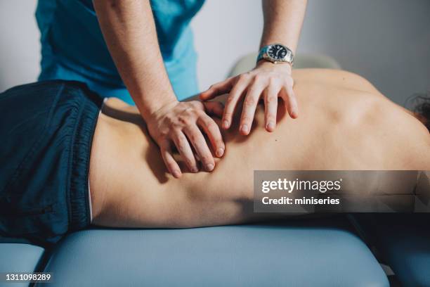 fermez-vous vers le haut du physiothérapeute massant le bas du dos - massagem photos et images de collection