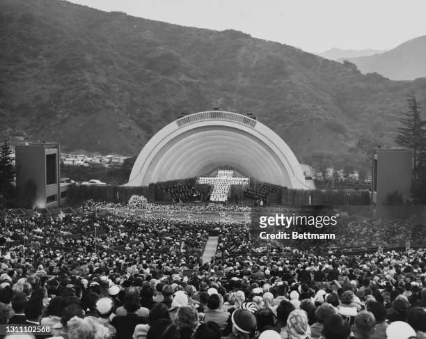 View from the back of the amphitheater as crowds sit for the Easter Sunrise Service at the Hollywood Bowl in Los Angeles, California, circa 1955....