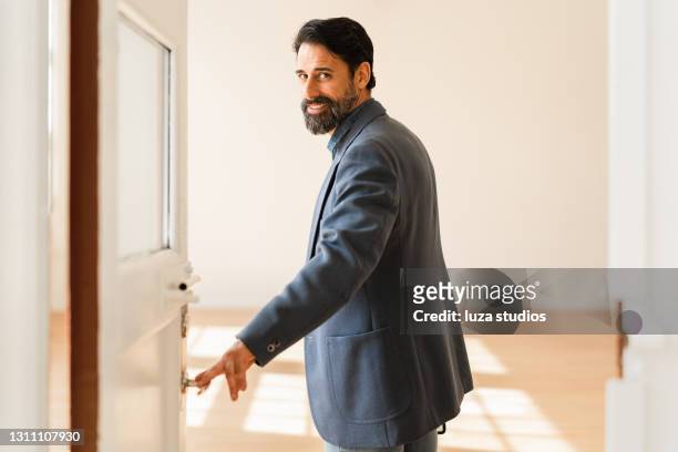 zakenman die de deuren aan een nieuwe bureauruimte opent - portrait stil stockfoto's en -beelden