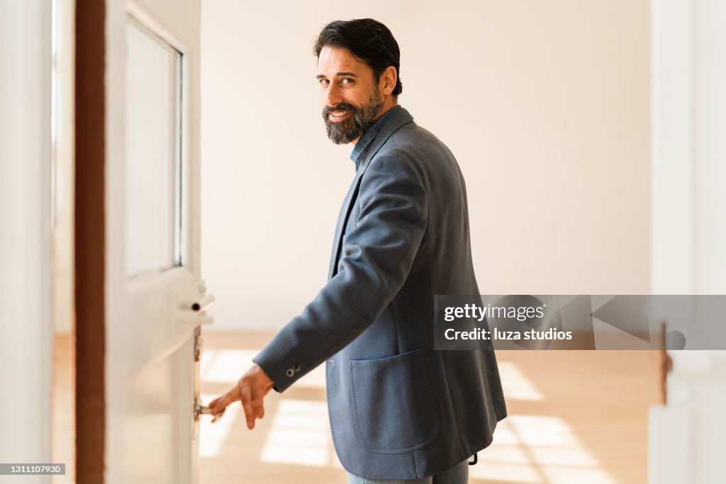 Businessman opening the doors to a new office space