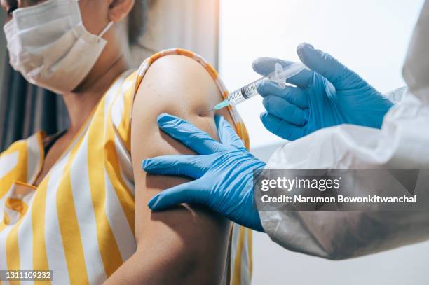 the doctor injecting the covid-19 vaccine for the woman - number 19 stock pictures, royalty-free photos & images