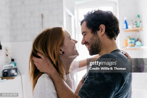 couple affectionately embracing and smiling together - hombre baño fotografías e imágenes de stock