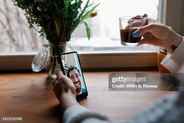 woman video calling her boyfriend with smartphone - zoom app stock pictures, royalty-free photos & images