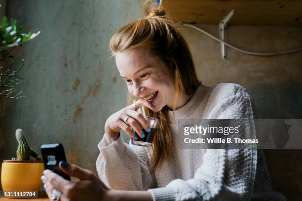 girl relaxing with coffee and video calling partner - mobile first fotografías e imágenes de stock