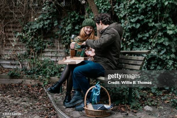 coupe who met online sharing pizza on park bench - park berlin stock-fotos und bilder