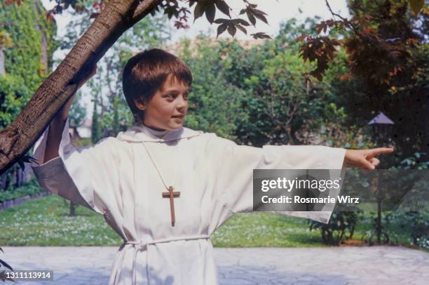 boy in garden pointing on first communion day - ambivere stock pictures, royalty-free photos & images