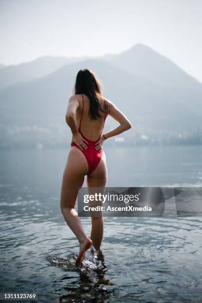 young woman relaxes in lake lugano in the morning - calm water stock pictures, royalty-free photos & images
