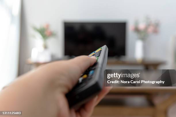 watching tv and using remote controller - plasma stockfoto's en -beelden