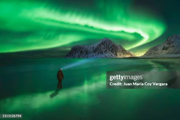 on another planet, northern lights dance across night skies at skagsanden beach, lofoten islands, nordland, northern norway, norway - gefrorener see stock-fotos und bilder