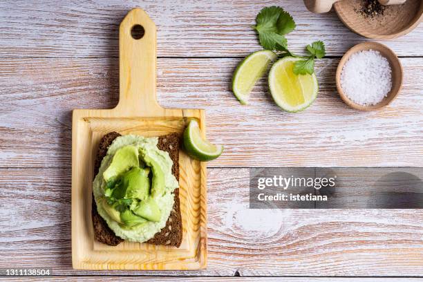 rye bread avocado hummus dip toast with  fresh avocado, lime, cilantro - roggebrood stockfoto's en -beelden