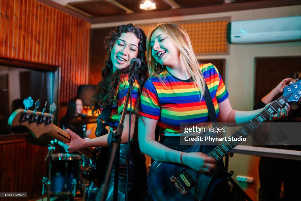 Waist up portrait of contemporary music band rehearsing in studio