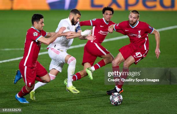 Karim Benzema of Real Madrid competes for the ball with Ozan Kabak of Liverpool FC during the UEFA Champions League Quarter Final match between Real...