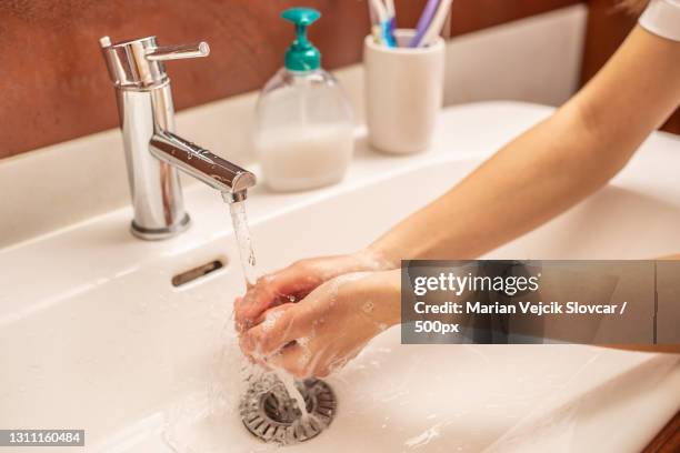 cropped image of teen girl washing hands in bathroom sink - washing hands close up stock pictures, royalty-free photos & images
