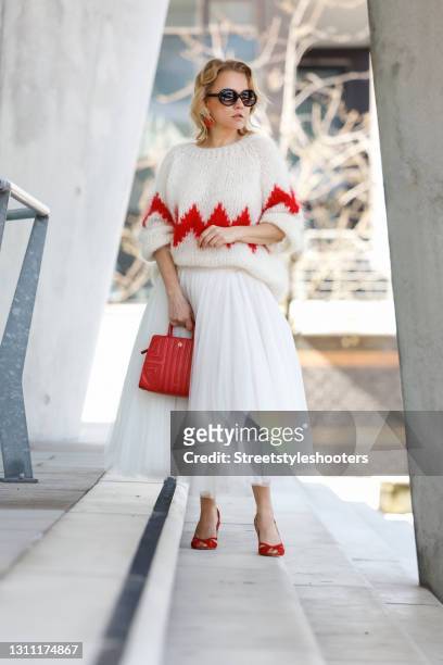 German actress and tv presenter Nova Meierhenrich wearing an ivory colored knitted pullover with red zigzag design by Douie Hamburg, a long white...