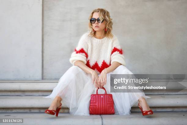 German actress and tv presenter Nova Meierhenrich wearing an ivory colored knitted pullover with red zigzag design by Douie Hamburg, a long white...