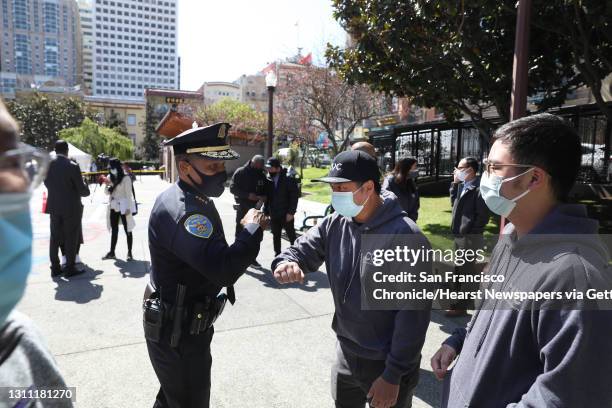 San Francisco Police Chief Bill Scott bids goodbye with an elbow bump to Coalition for Community Safety and Justice Anthony Tong , outreach, and...