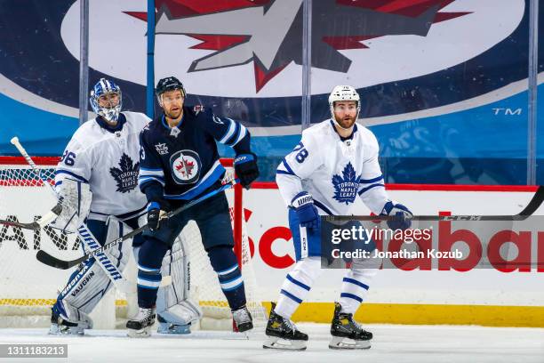 Trevor Lewis of the Winnipeg Jets keeps an eye on the play while goaltender Jack Campbell and TJ Brodie of the Toronto Maple Leafs defend during...