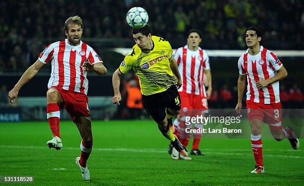 Robert Lewandowski of Dortmund jumps for the ball next to Olof Mellberg of Olympiacos during the UEFA Champions League group F match between Borussia...