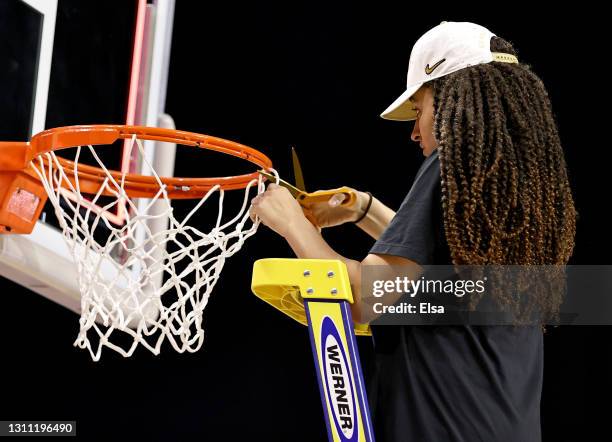 Haley Jones of the Stanford Cardinal cuts a piece of the net after the National Championship game of the 2021 NCAA Women's Basketball Tournament at...