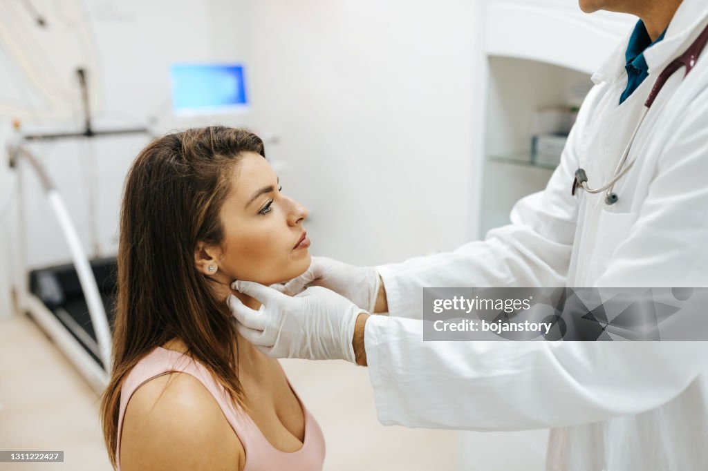 Male doctor examined the neck pain of a female patient