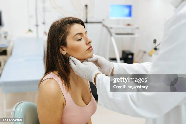 checking thyroid glands at the doctor - hashimotos thyroiditis stock pictures, royalty-free photos & images