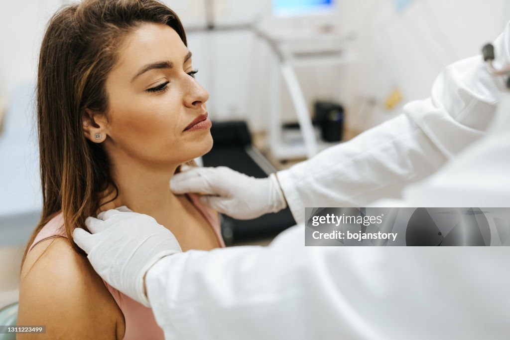 Il medico maschio ha esaminato il dolore al collo di una paziente