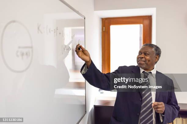 african - american high school teacher giving a lecture, writing on a white board - lecturer whiteboard stock pictures, royalty-free photos & images