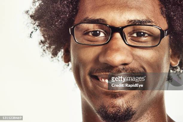 handsome young man with a characterful face, wearing glasses, smiles gently and kindly at the camera - kind face stock pictures, royalty-free photos & images