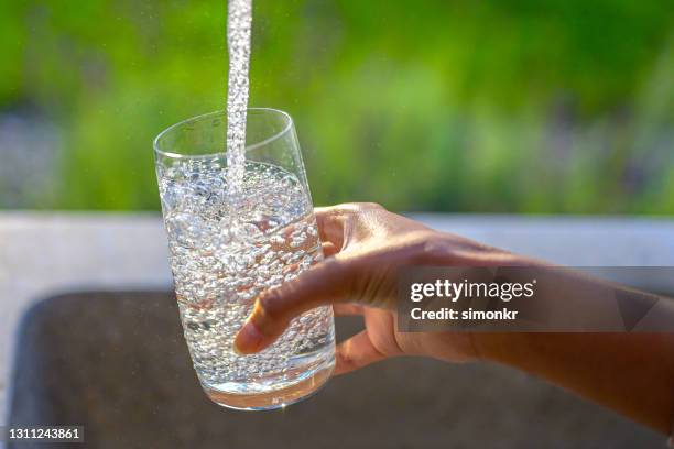 ガラスを水で満たす女性の手 - glass of water hand ストックフォトと画像