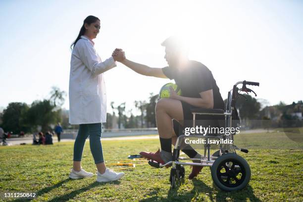 junge fußballer macht physiotherapie sitzung mit jungen ärztin. - sportmedizin happy stock-fotos und bilder