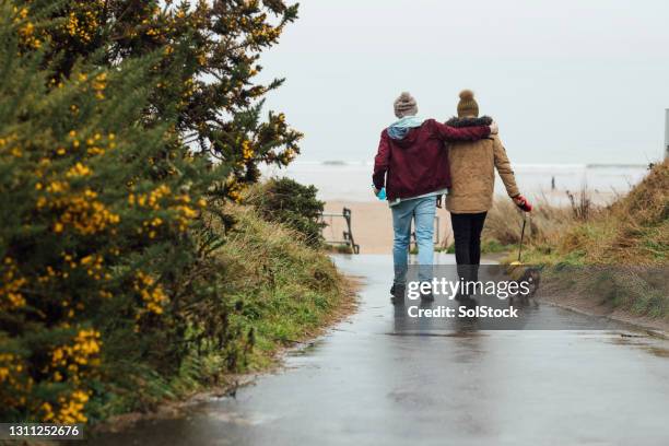 heading to the beach - romantic couple walking winter beach stock pictures, royalty-free photos & images