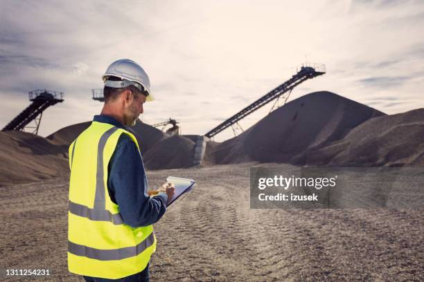 back view of inspector at open-pit mine - gravel quarry stock pictures, royalty-free photos & images