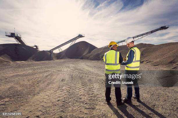 back view of open-pit mine workers - mining natural resources stock pictures, royalty-free photos & images
