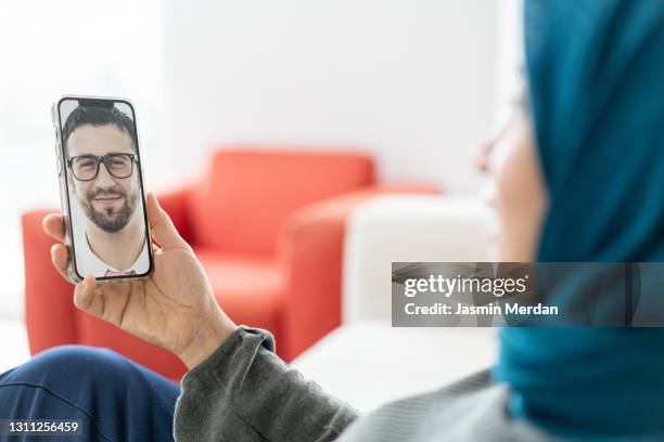 muslim adult woman talking with a man - smart card stock pictures, royalty-free photos & images